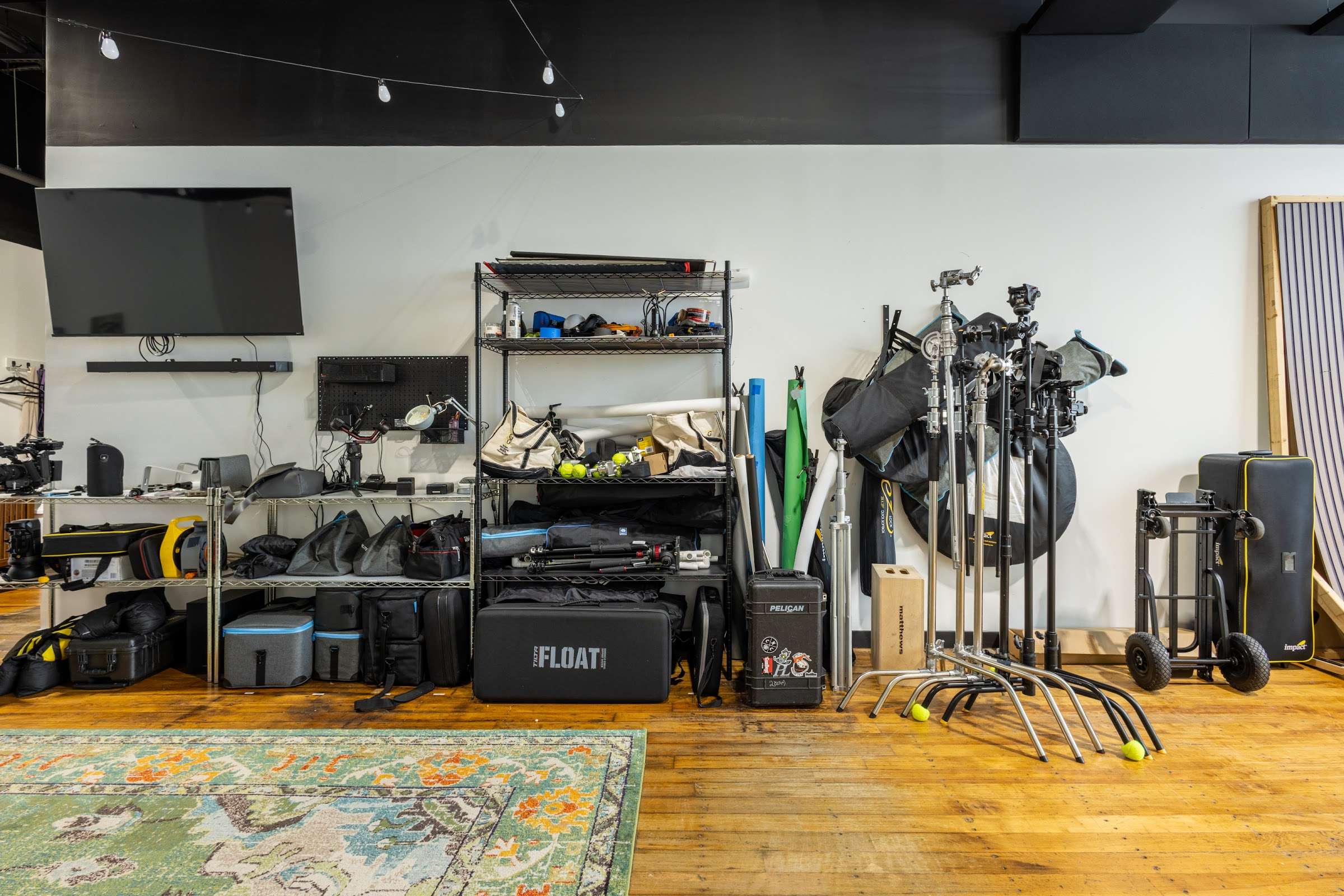 Studio 5 gear wall with lighting, C-stands, modifiers and backdrops